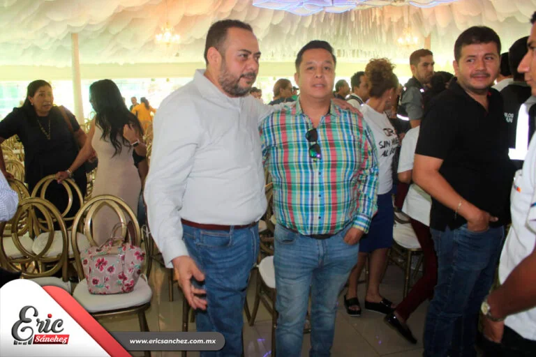 Eric Sánchez Árciga conversando con asistentes durante un evento comunitario bajo una carpa